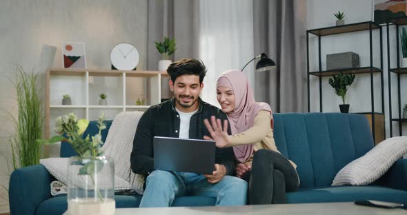 Arabic Couple Sitting on Comfortable Couch at Home During Video call