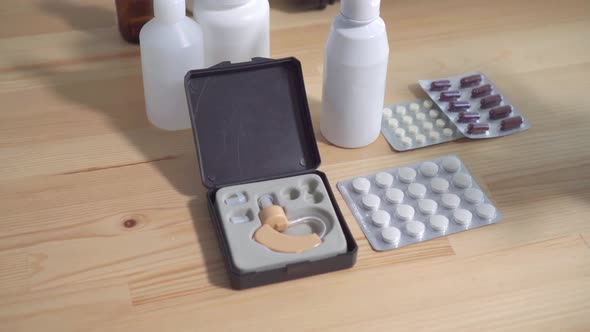 Close Up of Hearing Aid and Medicine on the Table