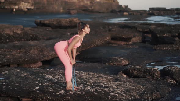 Side View Beautiful Young Woman Doing Exercises with Elastic Band Outdoor