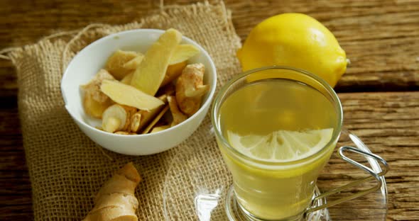 Lemon tea with ginger and lemon on wooden table 4k