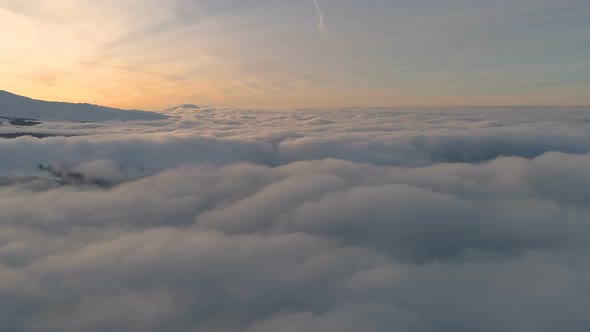 Yellow sunset sky above white fluffy clouds.