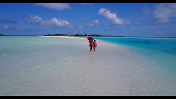 Family of two in love on tranquil sea view beach vacation by blue lagoon with white sandy background