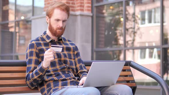 Online Shopping Failure for Redhead Beard Young Man Sitting on Bench