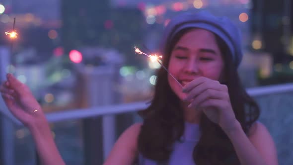 Young asian woman with sparklers is dancing and celebrating a new year. Fireworks,