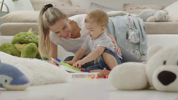 Happy smiling mom plays with her beautiful baby