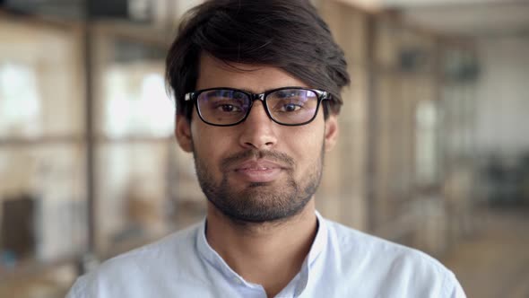 Headshot of Young Indian Businessman Wears Glasses Looks at Camera in Office