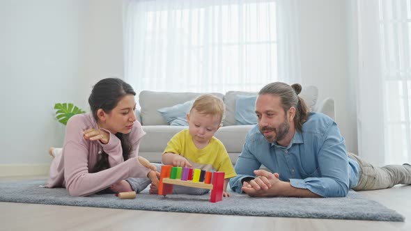 Caucasian happy loving parent play with baby toddler in living room. Activity relationship at home.