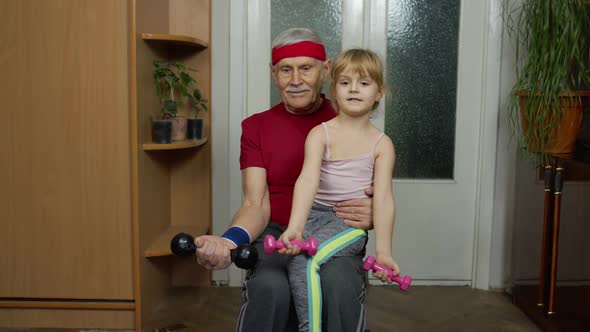 Active Grandfather Senior Man with Child Girl Doing Fitness Weight Lifting Exercises with Dumbbells