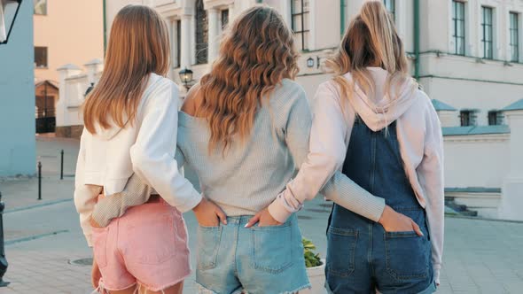 Three young female hipster friends posing outdoors