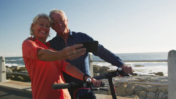 Senior couple taking picture alongside beach