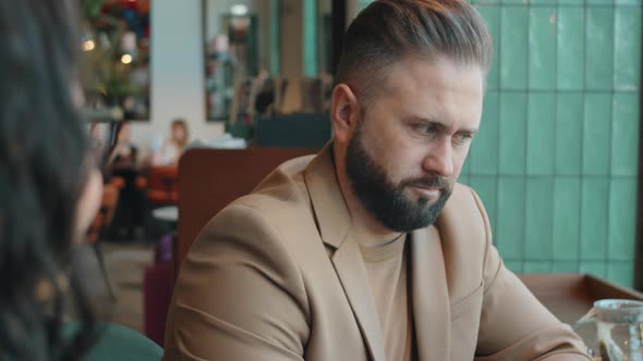 Businessman Talking with Female Colleague in Cafe