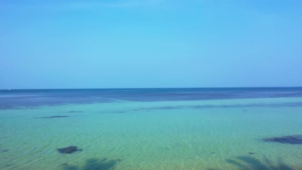 Aerial drone shot texture of idyllic coastline beach time by transparent lagoon and bright sand back