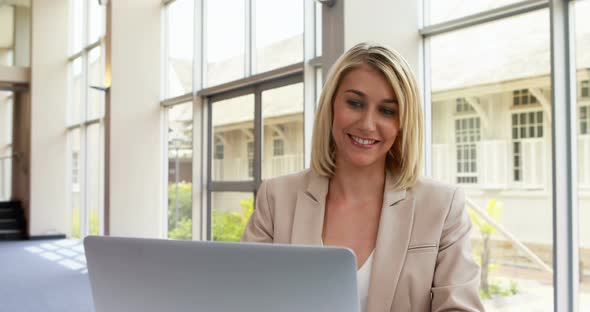 Businesswoman using laptop in office 