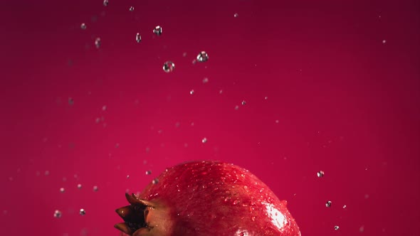 Flying of Pomegranate in Fuchsia Background in Slow Motion