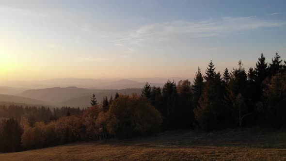 Flight over autumn mountains in the light of the setting sun.