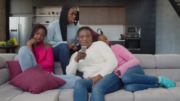 Happy African Family Watching Television on Sofa