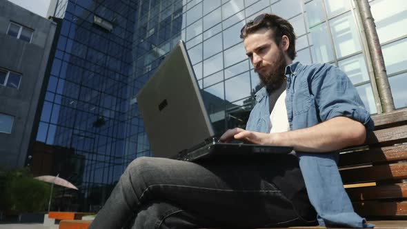 Man Uses Laptop Outdoors