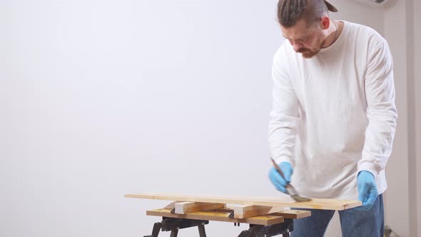 the Carpenter Covers the Wood with Oil with a Brush