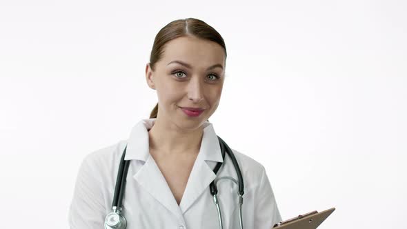 Female Therapist Looks at Tablet and Smiles, Snow-white Smile.