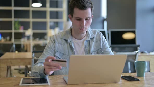 Young Designer Celebrating Successful Online Payment on Laptop