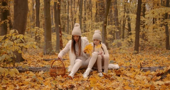 Young Mom and Daughter on a Picnic in Autumn