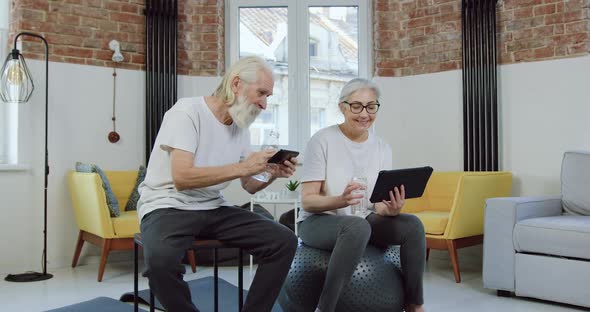 Senior Couple Enjoying Revisions Phone and Tablet Apps while Relaxing