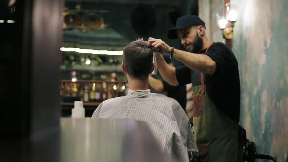 Bearded Hairdresser Spraying Water and Combing Wet Hair of His Male Client in a Retro Stylish