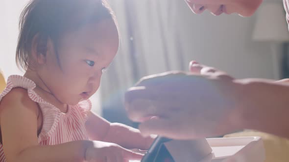 Excited Asian Baby Girl Watching Cartoon on Tablet