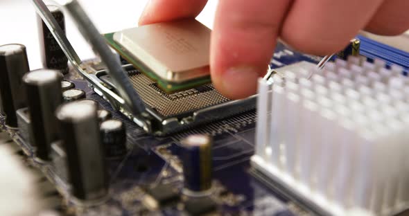 Technician fixing chip on motherboard