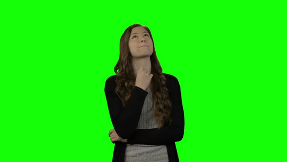 Smiling woman looking around against green screen