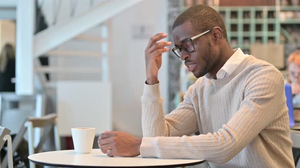 Concerned African Man Thinking in Cafe, Worrying 