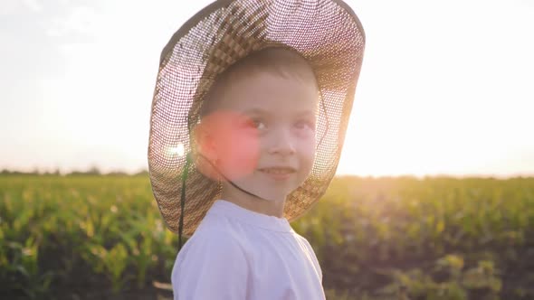 A Little Boy in a Hat Run Through a Cornfield