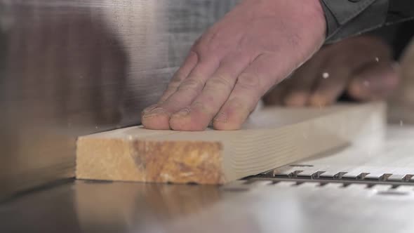 Slow Motion Shot of a Carpenter Trimming a Board Using a Thickness Planer