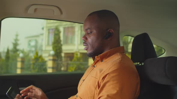 Businessman Using Hands-free Device in Car Backseat