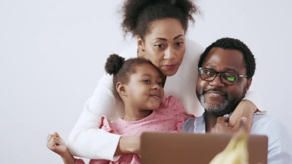 Smiling family looking at laptop