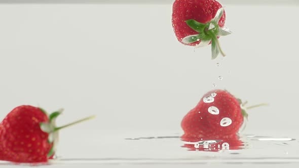 Fresh Strawberry Fruit Dropped Into Water Shot in Super Slow Motion