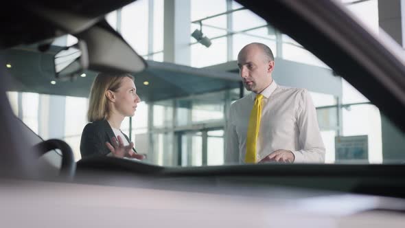 Attractive Woman Picks Up Her Car in a Car Dealership