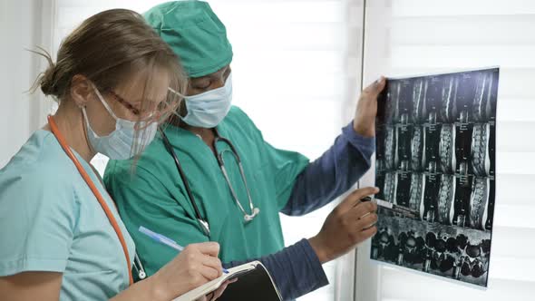 Young Dark-skinned Doctor Gives Directions To a Nurse. Concept of the Absence of Interracial