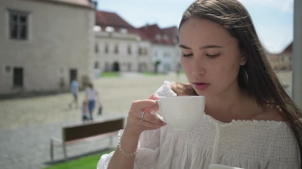 Girl Having Coffee in Street Cafe