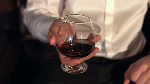 Man Keeping a Glass of Cognac Closeup
