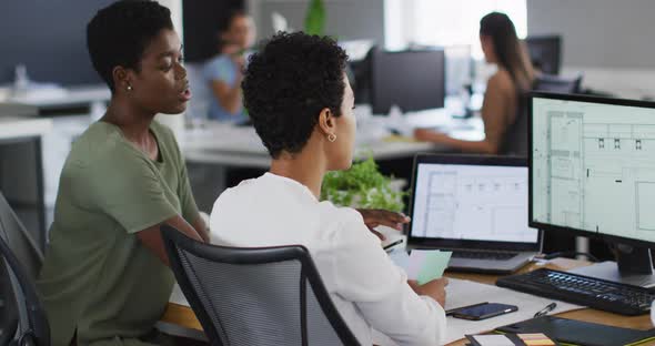 Two diverse businesswoman working together on laptop