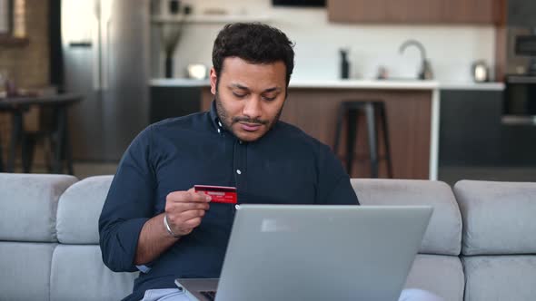 Multiethnic Hindu Freelancer Guy Using Laptop Computer for Shopping