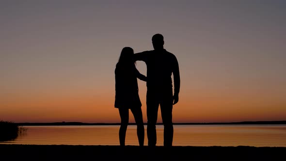 Couple Holding Hands Coming To The Beach And Enjoying The Sunset On The Sea