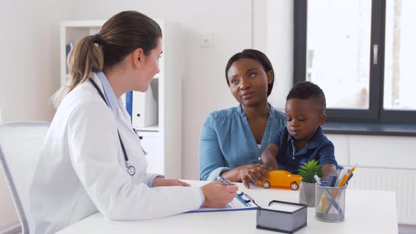 Happy Mother with Baby Son and Doctor at Clinic