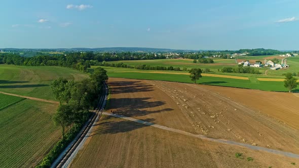 Aerial View of the Farm Countryside With Planted Fields and a Single Rail Road Track