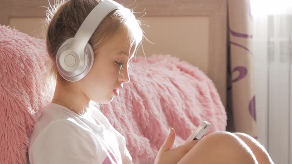 A School Girl Plays the Phone Lying on the Floor in Her Room, Along with Her Her Favorite Toys.