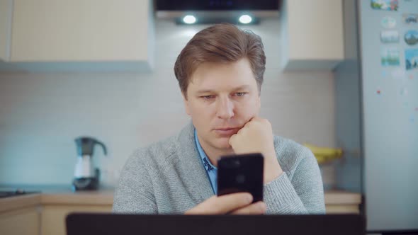 Attractive Man Using Mobile Phone at Home