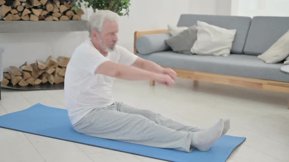 Old Man Doing Stretches on Yoga Mat at Home