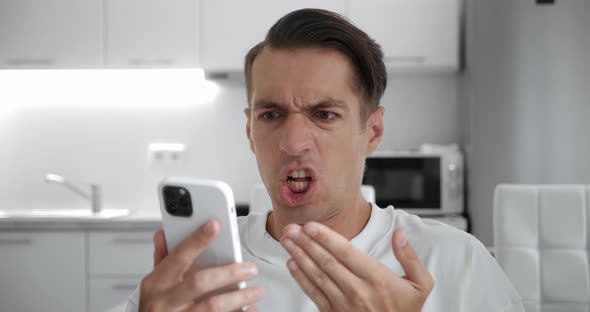 Angry Troubled Stressed Man Having Problem While Using Smartphone at Home