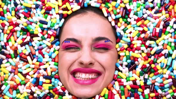 Beautiful girl acting inside a colored background made with pills